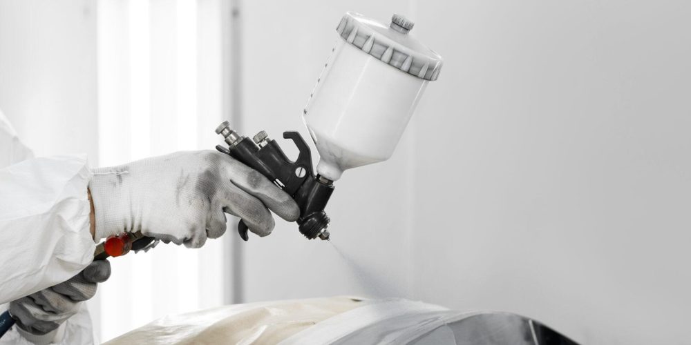 malarz-uzywajacy-pistoletu-malowania-samochodu-w-sklepie